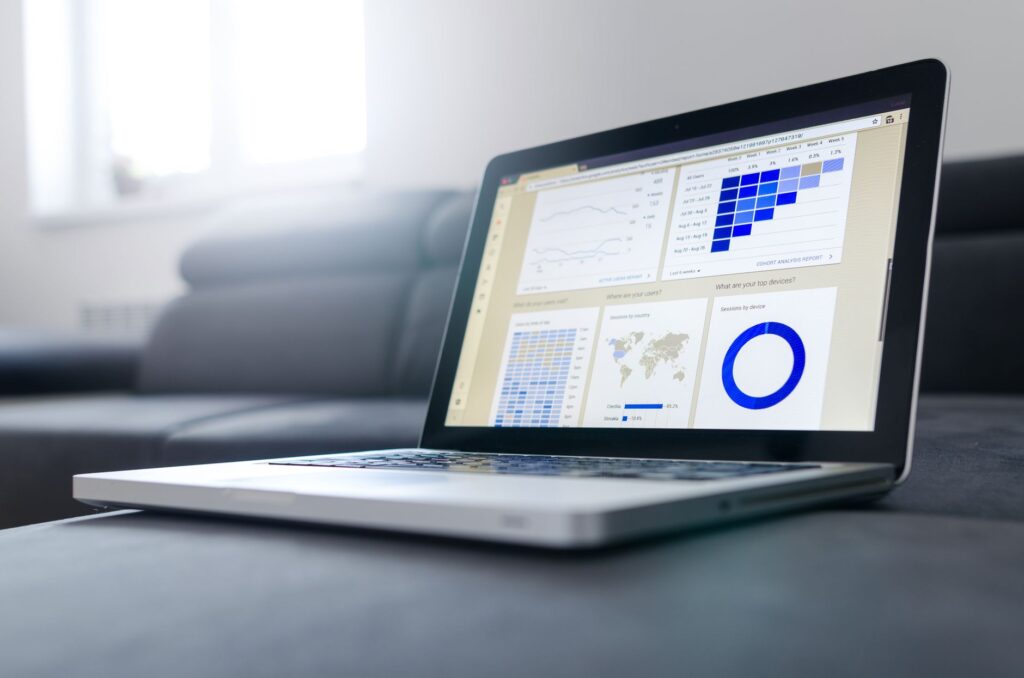 Laptop on a sofa showing an analytics dashboard with charts